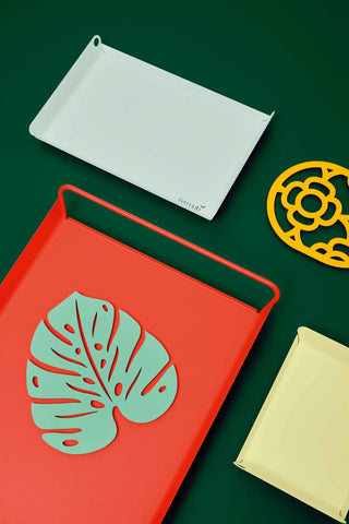 Découvrez le dessous de plat Monstera de Fermob. Un design végétal en acier ultra-résistant pour protéger votre table avec style. Fabriqué en France.