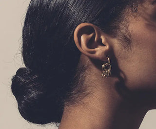 Découvrez les boucles d'oreilles Avi de Chic Alors chez CQFD Avignon. Un design géométrique d'anneaux entrelacés en or fin 24 carats, fabriqué à Paris.