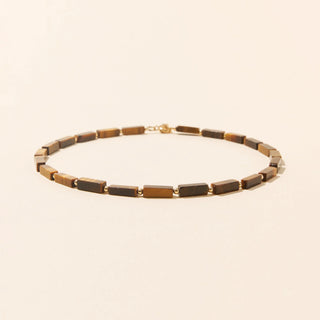 Découvrez le collier Œil du Tigre de Camille Colette Studio. Pierres naturelles géométriques et gold filled 14k résistant à l'eau. Fabriqué à Bordeaux chez CQFD Avignon.