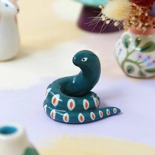 Découvrez la figurine Serpent en faïence Dodo Toucan chez CQFD Avignon. Sculptures de serpent modelée et peinte à la main à Paris. Pièces uniques de 4 cm.