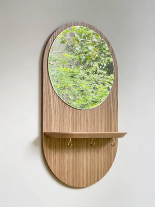 Craquez pour le miroir mural Éclipse de Reine Mère. Étagère en chêne, crochets noir/or et miroir écoresponsable. Un condensé de design breton chez CQFD Avignon.