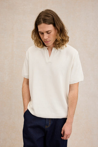 Découvrez le polo en maille guillochée Le Minor. Un coloris écru lumineux, un col ouvert minimaliste et une douceur absolue. Fabriqué en France. Disponible chez CQFD.