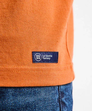 Adoptez le t-shirt homme Baptiste orange de La Gentle Factory chez CQFD Avignon. Conçu en coton et polyester recyclés, brodé vélo et fabriqué en France.